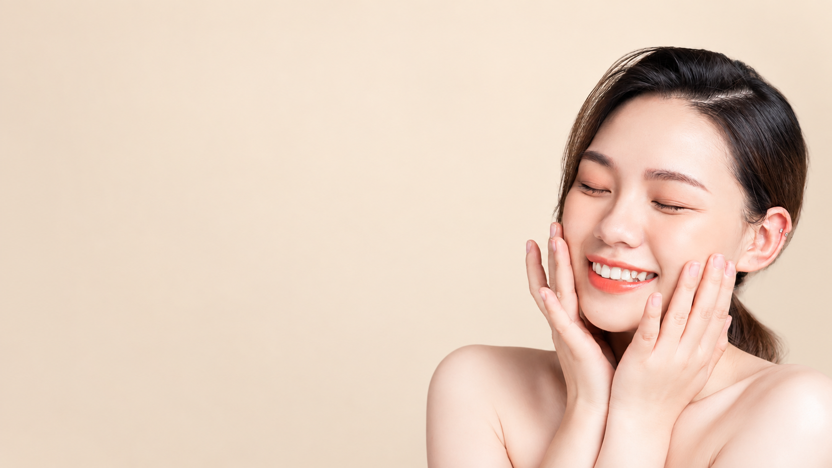 Smiling woman with radiant, glowing skin touching her face