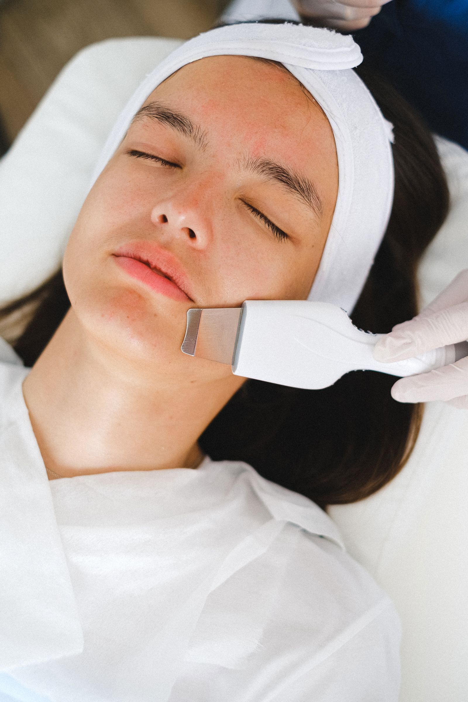 Aesthetician providing a facial treatment in a calm clinical setting