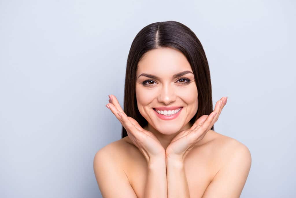 A woman smiling and showing the results of dermal fillers in Allen, TX